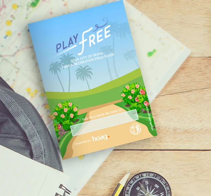Brochure featuring palm trees and flowers, titled "Play Free," lying on a map with a compass.