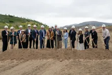 Groundbreaking ceremony with people in hard hats and shovels.