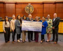 image of group of people holding a large funding check