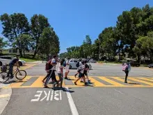 kids walking and bike riding in a crosswalk 