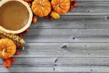 pumpkins and a pumpkin pie on a grey wood background