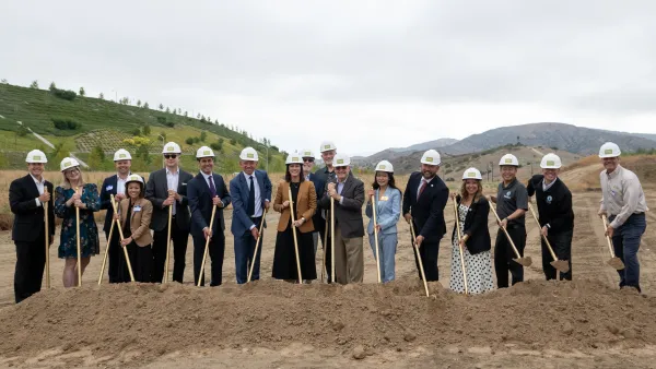 Groundbreaking ceremony with people in hard hats and shovels.