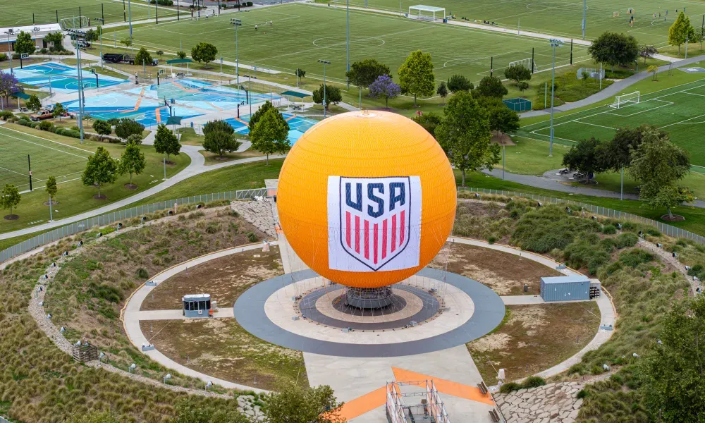 Large orange sphere with a USA logo in a recreational park.