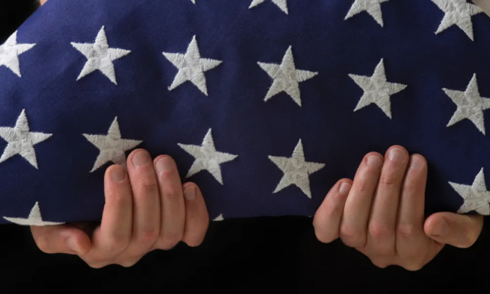 Image of person holding folded flag