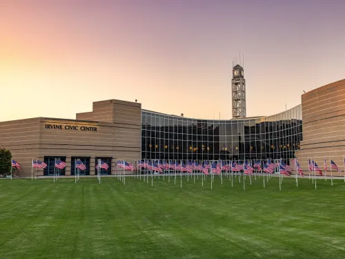 Irvine Civic Center and clock tower at sunset, with numerous American flags on the lawn.