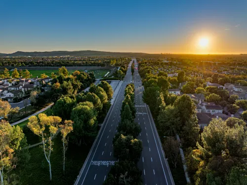 High level view of a two-way street with trees and housing