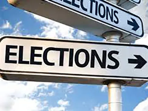 Two 'ELECTIONS' street signs pointing right on a pole under a blue sky.