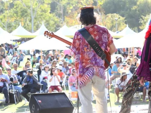 two people on a stage with a guitar looking out to a crowd